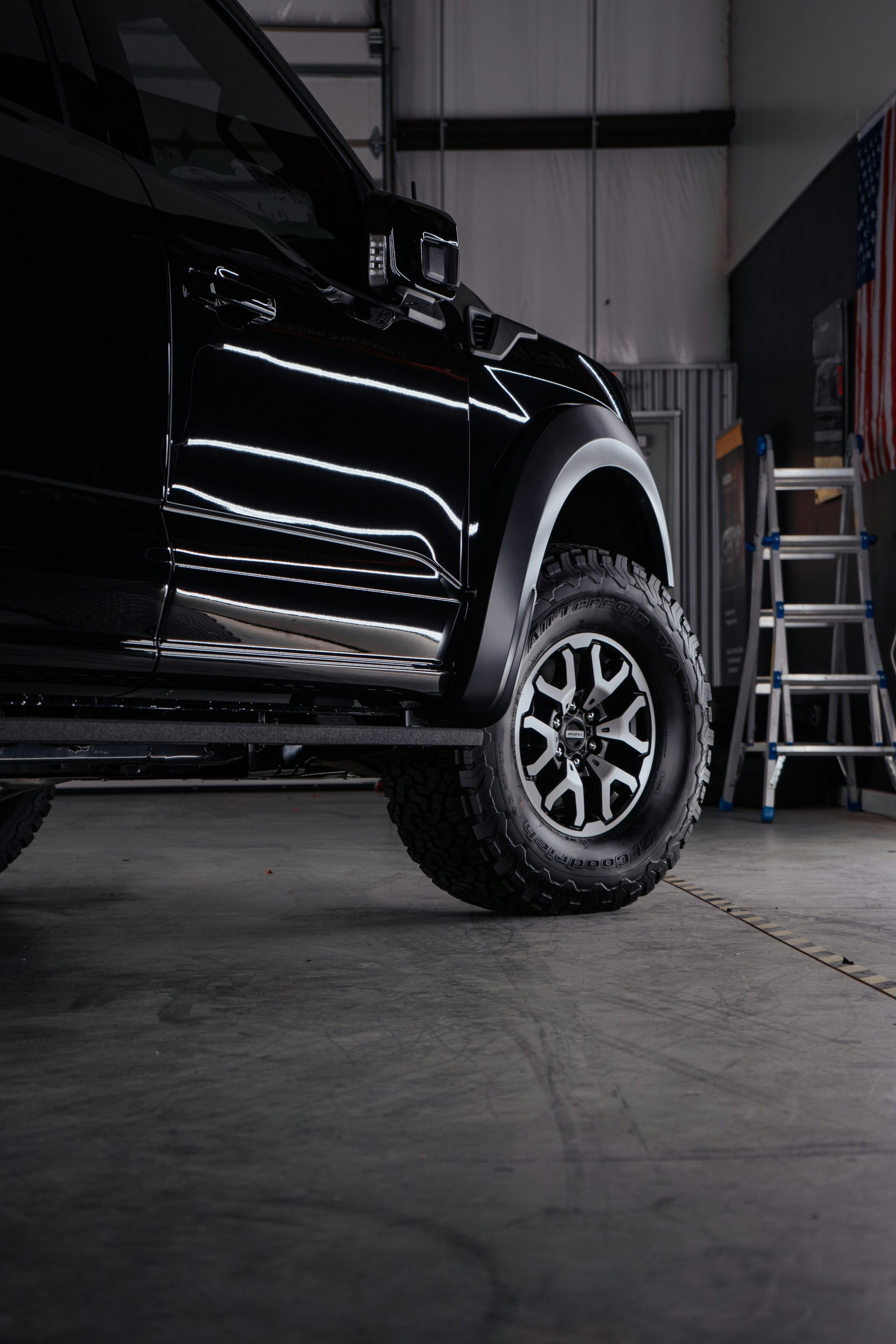 a truck parked inside of a garage next to a ladder